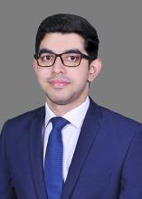 man with glasses in a blue suit smiling