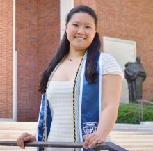 Woman smiling in front of building