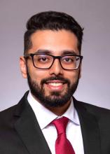 man in a red tie with glasses smiling