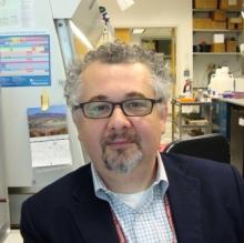 man with glasses and a dark blazer 