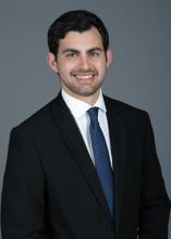 man with navy blue tie smiling