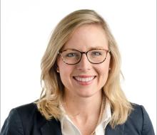 woman with blonde hair and glasses smiling