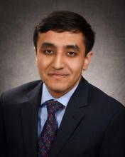 man in a dark suit smiling