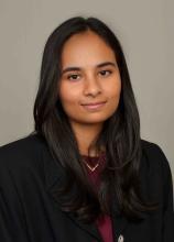 woman with a burgundy shirt smiling