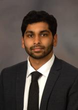 man in a black suit smiling