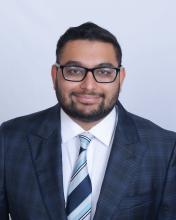 man smiling and wearing a suit