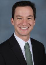 man in a suit with a green tie smiling