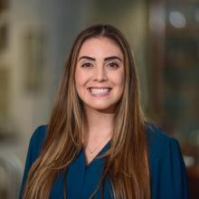 woman with long hair in a blue top smiling