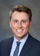 man smiling and wearing blue suit