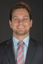 man in gray suit and striped tie smiling
