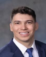 man with short hair and blue tie smiling