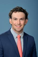 man with dark curly hair smiling