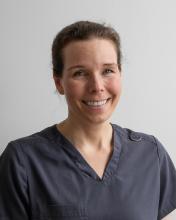 woman with hair tied back smiling