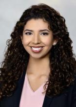 woman with long dark curly hair smiling