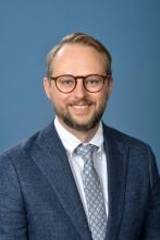 man with glasses and short blonde hair smiling