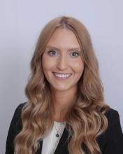 woman with long curled blonde hair smiling