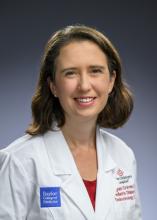 woman with short brown hair in a doctor coat