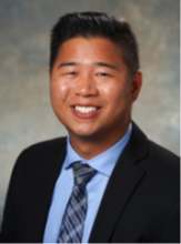 man with black blazer smiling