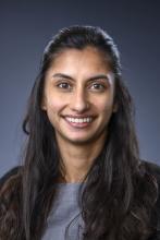 woman with half up half down dark hair smiling