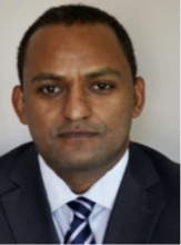 man with buzz cut in professional attire smiling