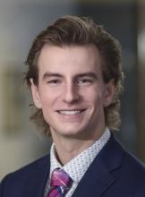 man with blonde hair to his shoulders smiling