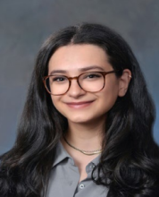 woman with dark hair and red glasses smiling