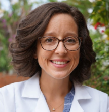 woman with curled short brown hair smiling