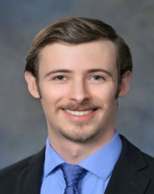 man with brown hair smiling