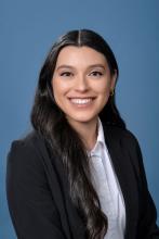 woman with long curled dark hair smiling