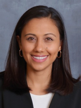 woman with dark shoulder length brown hair smiling