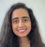 woman with dark slightly curly hair smiling