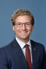 man with short curly blonde hair smiling