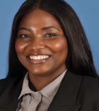 woman with black hair behind her shoulders smiling