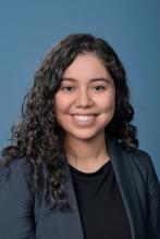woman with dark curly hair smiling