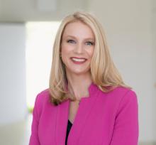 woman with blonde hair and hot pink blazer smiling