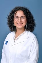 woman with glasses and curly hair smiling