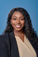 woman with long curly black hair smiling