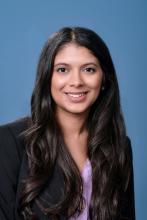 woman with long dark hair smiling with black blazer on