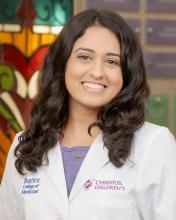 woman with side parted dark hair smiling