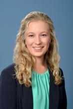 woman with curly half up, half down hair smiling