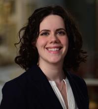 woman with dark short curled hair smiling