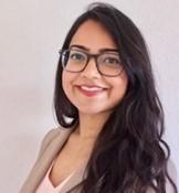 woman with dark hair and dark glasses smiling