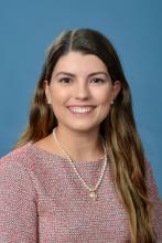 woman with long hair and a pink top smiling