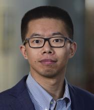 man with buzz cut and black rectangle glasses smiling