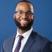 man with square glasses smiling