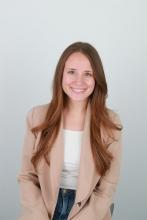 Woman smiling in front of grey background