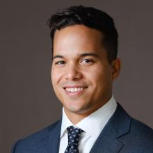 man with short, slightly curled hair smiling