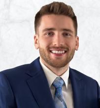Man smiling in front of grey background