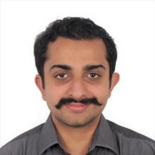 man with dark hair and mustache smiling