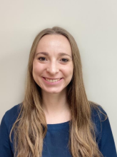 Woman smiling in front of grey background